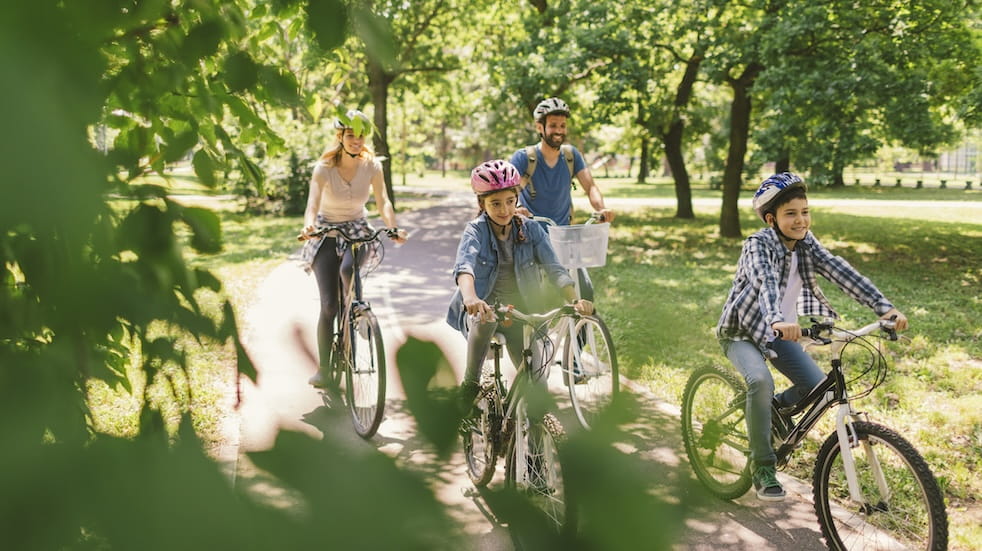 Family riding bicycle in the public park together